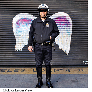 Policeman posing in front of Colette Miller's painted wings