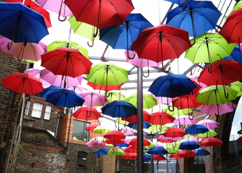 Brightly colored umbrellas suspended in the air in London.