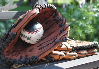 A baseball and glove at the park