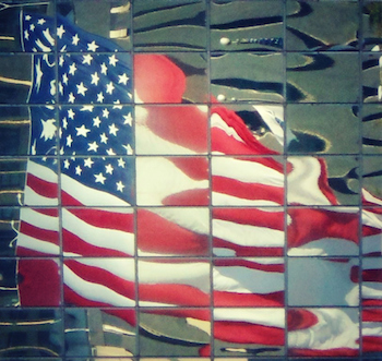 Flag reflected in a building's mirrored exterior. Photo by Edie Melson.