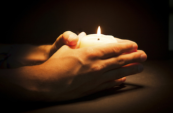 Hands cupping a candle. Photo by camaralenta, Thinkstock.