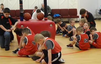 Basketball players kneel after a game. Photo by Michelle Cox.
