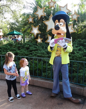 A couple of grandkids regard Pluto at Disney World.
