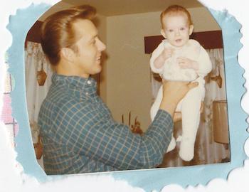 Shawnelle as a baby being held by her dad.