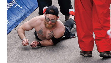 Micah crawling toward the Boston Marathon finish line after his legs locked up at Mile 22